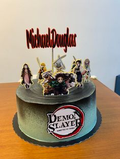 there is a cake that has been decorated with cartoon characters on it and the name demon slayer