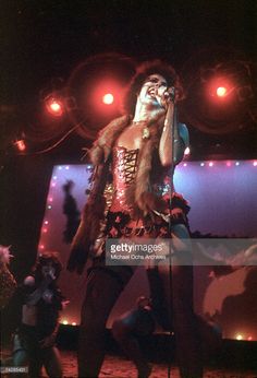 a man with long hair on stage holding a microphone