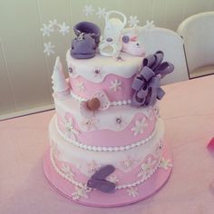 a three tiered cake decorated with pink and purple decorations