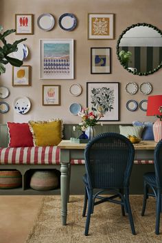 a living room filled with furniture and lots of pictures on the wall above it's table