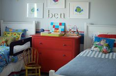 two children's beds in a child's bedroom with pictures on the wall