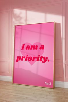 a pink poster with the words i am a priority on it in front of a pink wall