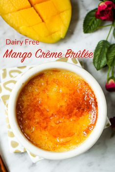 mango creme brulee in a white bowl next to fresh fruit