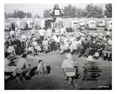 an old black and white photo of people sitting in lawn chairs