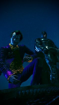 two men dressed as batman and joker in the dark