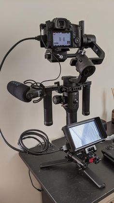 a video camera sitting on top of a table next to a laptop computer and other electronics