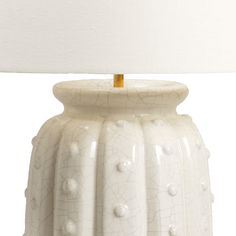 a white ceramic table lamp with a light on top