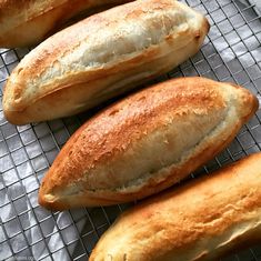 three loaves of bread sitting on top of a cooling rack