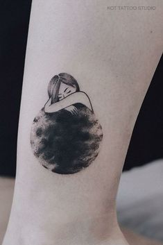 a black and white photo of a woman's leg with a tattoo on it