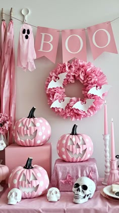 a table topped with lots of pink decorations next to a sign that says boo on it