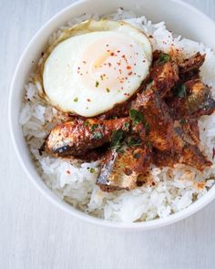 a bowl filled with rice, meat and an egg