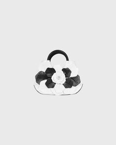 The SCARLET-MM is an updated version of the SCARLET-BB. This white bag features a black patent leather bottom and contrasting black and white textured petals. The SCARLET-MM is finished with two black circular handles and a zippered closure. The ideal size of this piece makes this bag the perfect accessory for any occasion. #html-body [data-pb-style="62FB5CA0A1DFA"]{justify-content: flex-start; display: flex; flex-direction: column; background-position: left top; background-size: cover; backgrou Lana Shirt, Black And White Handbag, Luxury Shirts, Black And White Bags, Floral Handbags, Spring Sneakers, White Handbag, Top Background, Airport Fashion