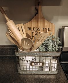 kitchen utensils and cutting boards in a metal basket on a counter top next to a stove