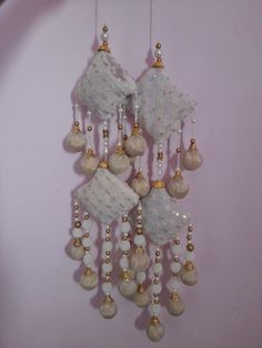 a white and gold wind chime hanging from a wall