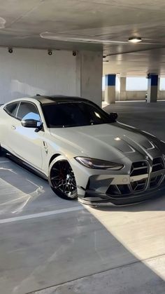 a white masera parked in a parking garage next to another car with black rims