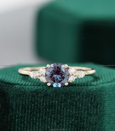 a close up of a ring on top of a green velvet cushion with diamonds around it