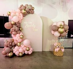 balloons are arranged in the shape of a letter and teddy bear on display at a baby shower