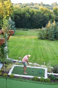 a man playing mini golf in his backyard