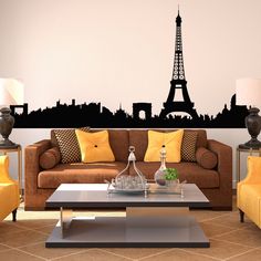 a living room filled with furniture and a large wall sticker in the shape of the eiffel tower