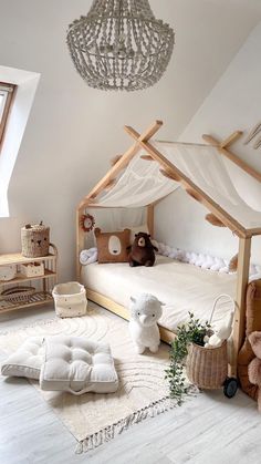 a child's bedroom with a canopy bed and stuffed animals on the floor in front of it