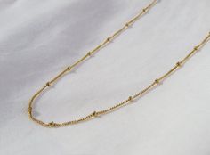 Perfect dainty piece to add to your collection for a layered look. This gold bead chain necklace can be worn alone or can be complemented with other necklaces for a layered look. Made in high-quality and authentic 14k gold-filled!Made in America!Fast Processing Time:It will take me 1-3 days to ship out your item.Packaging:Comes in a gift box with a pink ribbon. Perfect for gifting!Material:14k Gold Filled *This is authentic gold-filled!*Gold-filled items have a higher value compared to "plated" Trendy Gold Ball Chain Necklace, Trendy Gold Beaded Necklace For Everyday, Minimalist Beaded Chain Layered Necklace As Gift, Trendy Gold Beaded Chain Choker, Dainty Clavicle Chain Necklace With Round Beads, Minimalist Chain Necklace With Adjustable Chain And Round Beads, Gold Minimalist Layered Necklace With Beaded Chain, Minimalist Ball Chain Necklace For Layering, Ball Chain Link Necklace For Gifts