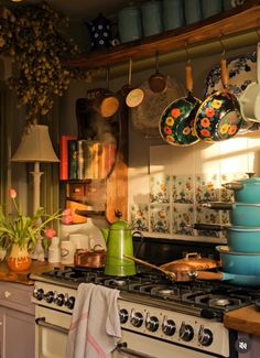 a kitchen with pots and pans hanging on the wall above the stove top oven