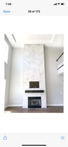 an image of a fireplace in the middle of a room with white walls and wood floors