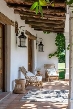 an outdoor patio with chairs and lamps on the wall