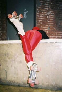 a man riding a skateboard down the side of a cement wall next to a brick building