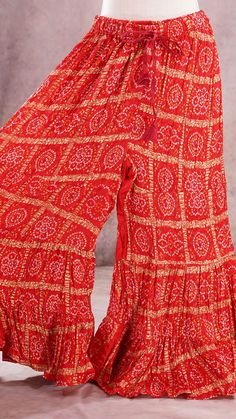 PRODUCT DETAILS These are beautiful Bandhini Palazzos pants that are tiered and have flary hem. The waist has a stretch elastic band with tying strings for a good fit. It is made of paper silk fabric, which has a very good flow. It resembles crushed satin silk. You can wear this with an Indian Kurti or a stylist western top!! Your creativity is the limit with these colorful, printed Palazzo pants! :) Size: One Size Length: 38 inches In seam: 25 inches Waist: expands upto 42 inches Material & Car Festive Fitted Palazzo Set With Ruffles, Fitted Ruffled Palazzo Set For Festive Occasions, Traditional Ruffled Sharara For Navratri, Bollywood Style Ruffled Sharara For Summer, Summer Bollywood Sharara With Ruffles, Festive Red Sharara With Ruffles, Festive Fitted Sets With Ruffled Skirt, Fitted Festive Sets With Ruffled Skirt, Traditional Navratri Tiered Skirt Set