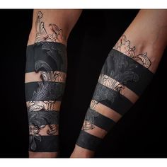 two people with tattoos on their arms and legs, one is wearing black striped stockings