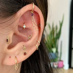 a close up of a person's ear with different types of piercings on it