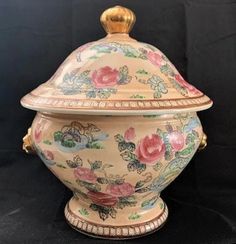 an ornately decorated urn with flowers on the lid and gold trimmings