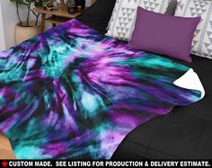 a bed covered in purple and green tie dyed sheets