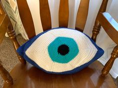 a crocheted eye pillow sitting on top of a wooden chair