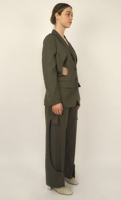 Khaki Tencel Jacket Notched lapel collar Straight cut with a slight adjustment Closure with three buttons on the front Two patch pockets on the sides Two rounded openings on the sides Shoulder panels that go inside the openings Single-breasted Crafted in khaki Tencel, the Kinbaku jacket is the flagship piece of this collection. The two rounded shoulder panels are a distinctive signature of the Louise Marcaud brand. They add a bold and avant-garde touch to the jacket. You can choose to wear it as Fall Khaki Blazer With Flap Pockets, Green Utility Jacket With Welt Pockets For Work, Green Notch Lapel Blazer With Pockets, Khaki Blazer With Lapel Collar And Pockets, Khaki Blazer With Pockets And Lapel Collar, Khaki Single-breasted Utility Jacket With Lapel Collar, Khaki Single Breasted Blazer With Lapel Collar, Khaki Blazer With Patch Pockets And Lapel Collar, Khaki Military Utility Jacket With Welt Pockets