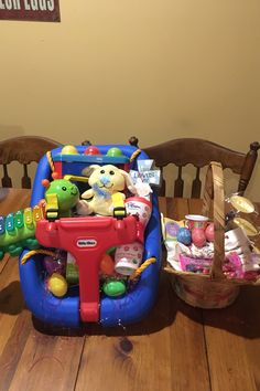 an inflatable toy car sitting on top of a wooden table next to a basket filled with toys