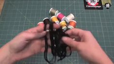 a person is holding several spools of thread