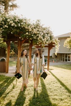 two women walking in the grass holding hands