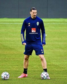 a man standing next to a soccer ball on a field