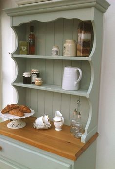 an old fashioned hutch with bread and coffee on the counter top in front of it