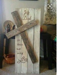 a cross made out of wood with words written on it and a basket next to it