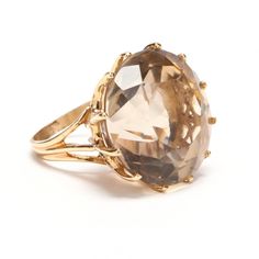 Exquisite 14 karat yellow gold ring set to the front with one round-cut smoky quartz measuring approximately 22.7 millimeters in diameter and weighing an estimated 48.72 carats. The ring is stamped 14K. It is a size 3 and can be re-sized to fit by your local jeweler. It weighs approximately 15.02 grams. There is a small chip to the cutlet; otherwise, very good estate condition. We are listing several pieces of estate jewelry, along with other items fresh from fine North Carolina estates. We are Timeless Gold Topaz Round Ring, Classic Smoky Quartz Rings For Formal Occasions, Classic Smoky Quartz Jewelry For Formal Occasions, Classic Formal Smoky Quartz Rings, Faceted Topaz Ring For Formal Occasions, Formal Faceted Topaz Round Ring, Formal Faceted Topaz Ring, Sparkly Ring, Lapis Lazuli Earrings