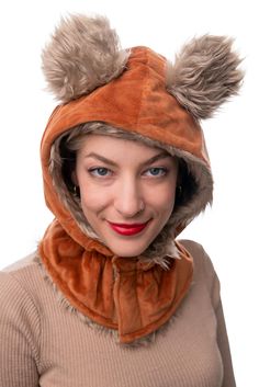 a woman wearing a brown hat with two furry ears on it's head and a scarf around her neck