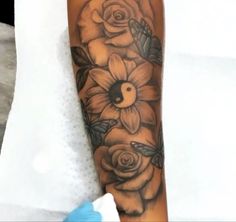 a woman's arm with flowers on it and a bird in the middle,