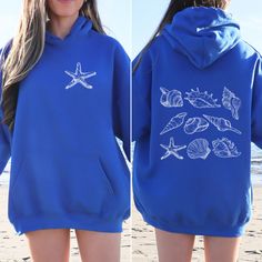 🐚Dive into coastal charm with our Seashell Hoodie! 🌊 Featuring starfish on the front and shells on the back, this unisex sweatshirt is perfect for beach lovers and seashell collectors alike.  Whether you're strolling along sandy shores or cozying up at home, this Coconut Girl Sweatshirt is the ultimate ode to seaside serenity. 🏖️ You can combine this product with this other one: https://ezirdesignstudio.etsy.com/listing/1709859009 ✨ Oversized Style: Immerse yourself in laid-back charm with ou Blue Hooded Tops For Beach, Blue Hooded Top For Beach, Blue Hooded Tops For The Beach, Sweatshirts On The Beach, Blue Hooded Beach Tops, Trendy Hooded Sweatshirt For Beach Season, Beach Season Cotton Hoodie With Graphic Print, Beach Season Graphic Print Hoodie Sweatshirt, 2025 Aesthetic