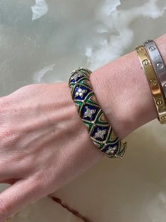 1960s 14k gold bracelet, adorned with approx. 2.60ctw SI1/H diamonds, blue and green enamel. DESIGNER: Not Signed MATERIAL: 14k Gold GEMSTONES: Diamond DIMENSIONS: Bracelet will fit approx. 7" wrist and is 15mm wide. MARKED/TESTED: Tested 14k. WEIGHT: 82.1 grams. CONDITION: Previously Owned, Excellent Condition. Designer Enamel Bangle Jewelry, Luxury Green Enamel Jewelry, Designer Blue Bracelet Jewelry, Sign Materials, Green Enamel, Gold Enamel, Stunning Jewellery, Blue And Green, 1960s