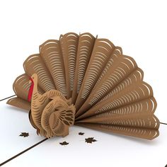 a paper turkey is on the floor with its tail folded up and it's head turned to the side