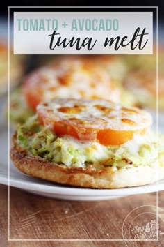 an egg and tomato sandwich on a white plate with other food items in the background