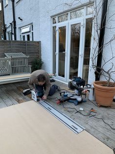 a man is working on an outdoor project in his backyard with wood planks and tools